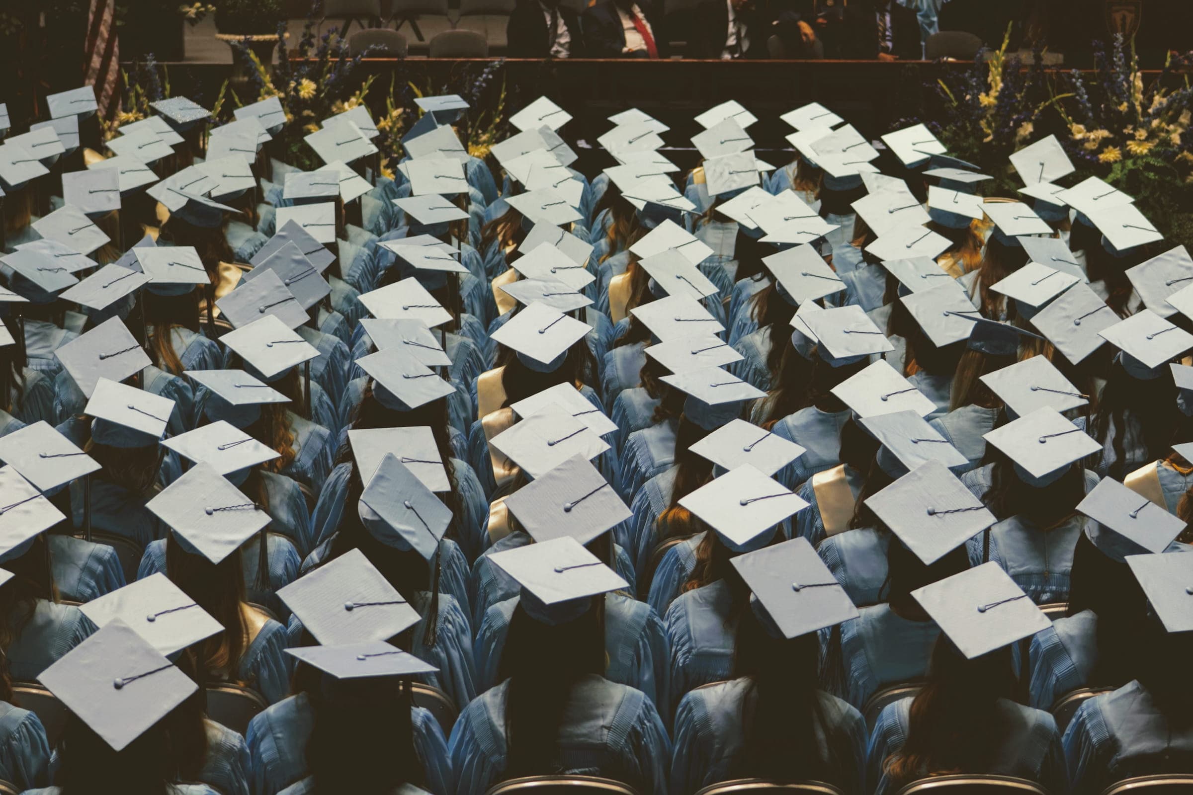 Studenter på examensceremoni med hattar
